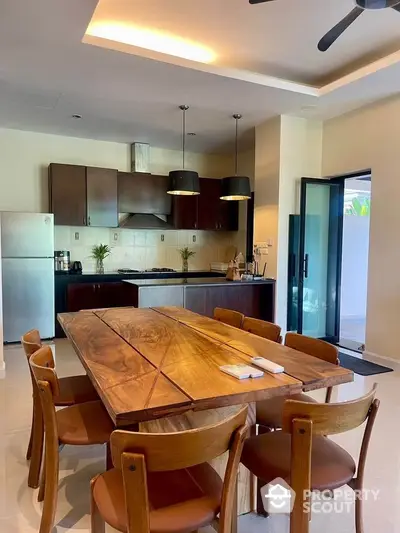 Modern kitchen with wooden dining table and sleek appliances