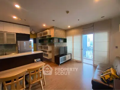 Modern open-layout living room with city view, stylish shelving, and cozy seating area.