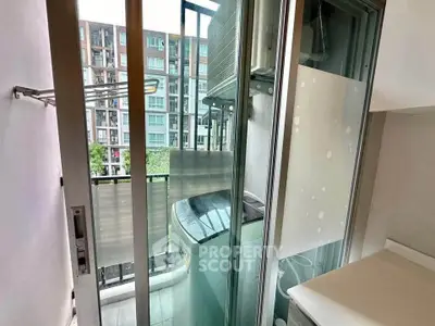 Compact balcony with washing machine and urban view