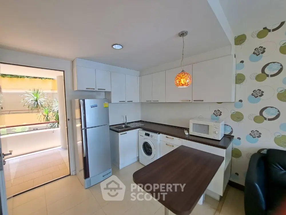 Modern kitchen with sleek appliances and stylish lighting in a contemporary apartment.
