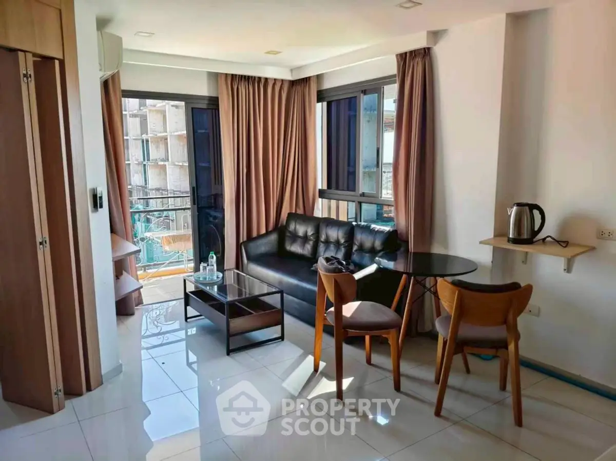 Modern living room with sleek furniture and large windows offering natural light.