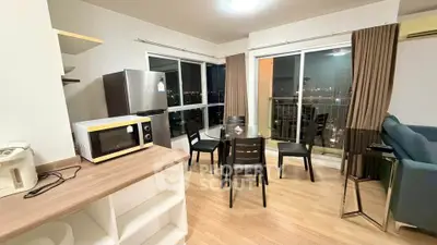 Modern open-plan living room with dining area and city view balcony.