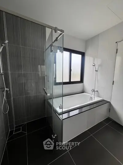 Modern bathroom with sleek design featuring a glass shower and bathtub.