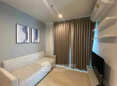 Modern living room with sleek sofa, wall art, and flat-screen TV, perfect for cozy relaxation.