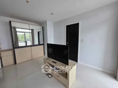 Modern living room with sleek TV and mirrored wardrobe, bright and spacious.
