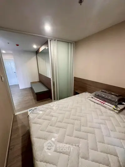 Modern bedroom with sliding glass doors and stylish wood accents in a contemporary apartment.