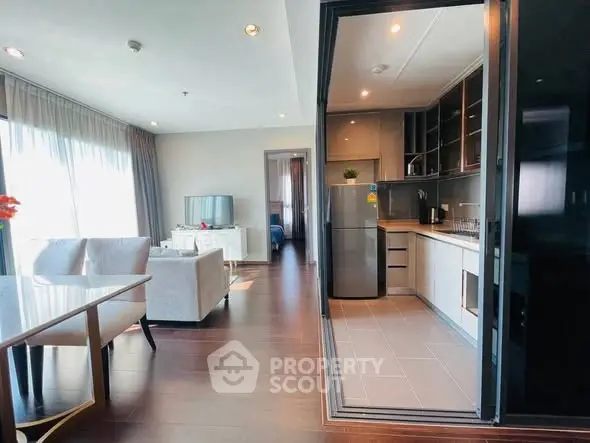 Modern open-layout living room and kitchen with sleek design and natural light.