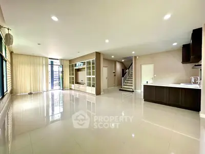 Spacious modern living room with open kitchen and sleek staircase