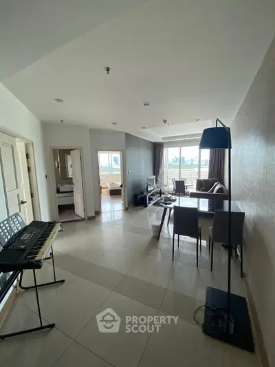 Spacious modern living room with city view, stylish furniture, and natural light.