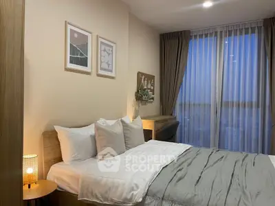 Cozy bedroom with modern decor and large window offering stunning city views.