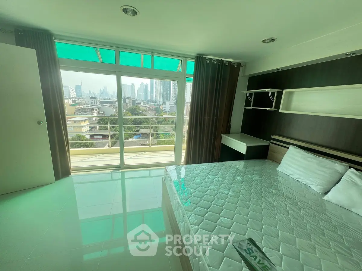 Spacious bedroom with city view and balcony access in modern apartment