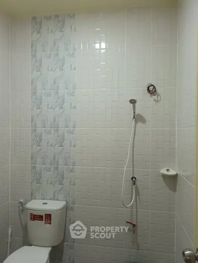 Modern bathroom with sleek white tiles and shower setup