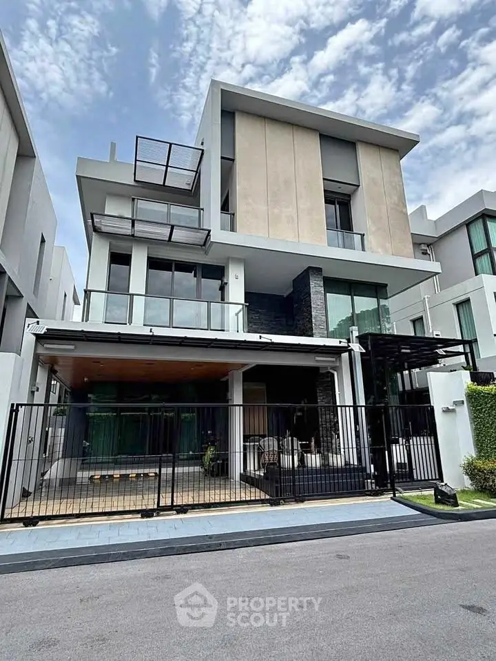 Modern multi-story house with sleek design and spacious balcony in upscale neighborhood.