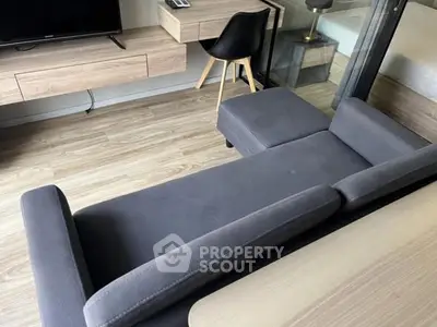 Modern living room with stylish gray sofa and wooden flooring