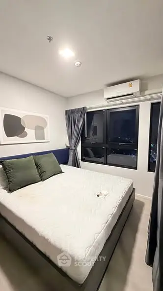 Modern bedroom with large windows and stylish decor in high-rise apartment.