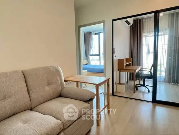 Modern apartment interior with cozy living room and study area, featuring stylish furniture and natural light.