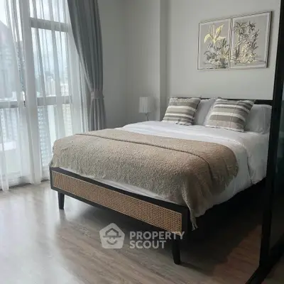 Luxurious bedroom with city view, featuring elegant decor and large windows for natural light.