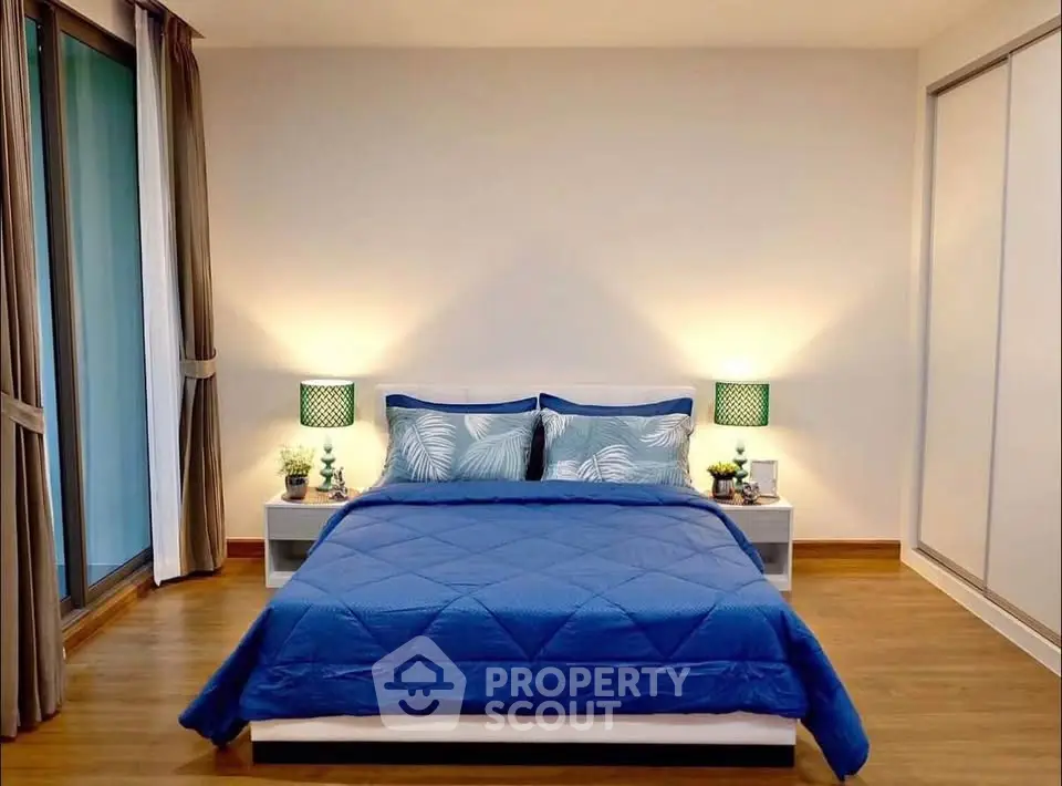 Modern bedroom with blue bedding and stylish decor in a cozy apartment.