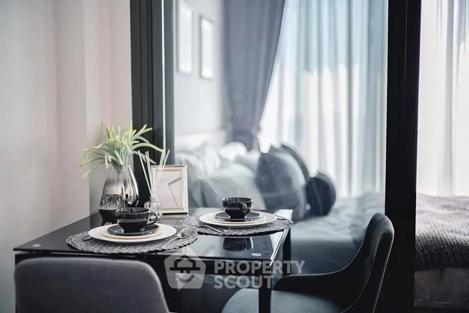 Modern dining area with elegant table setting and view into cozy bedroom