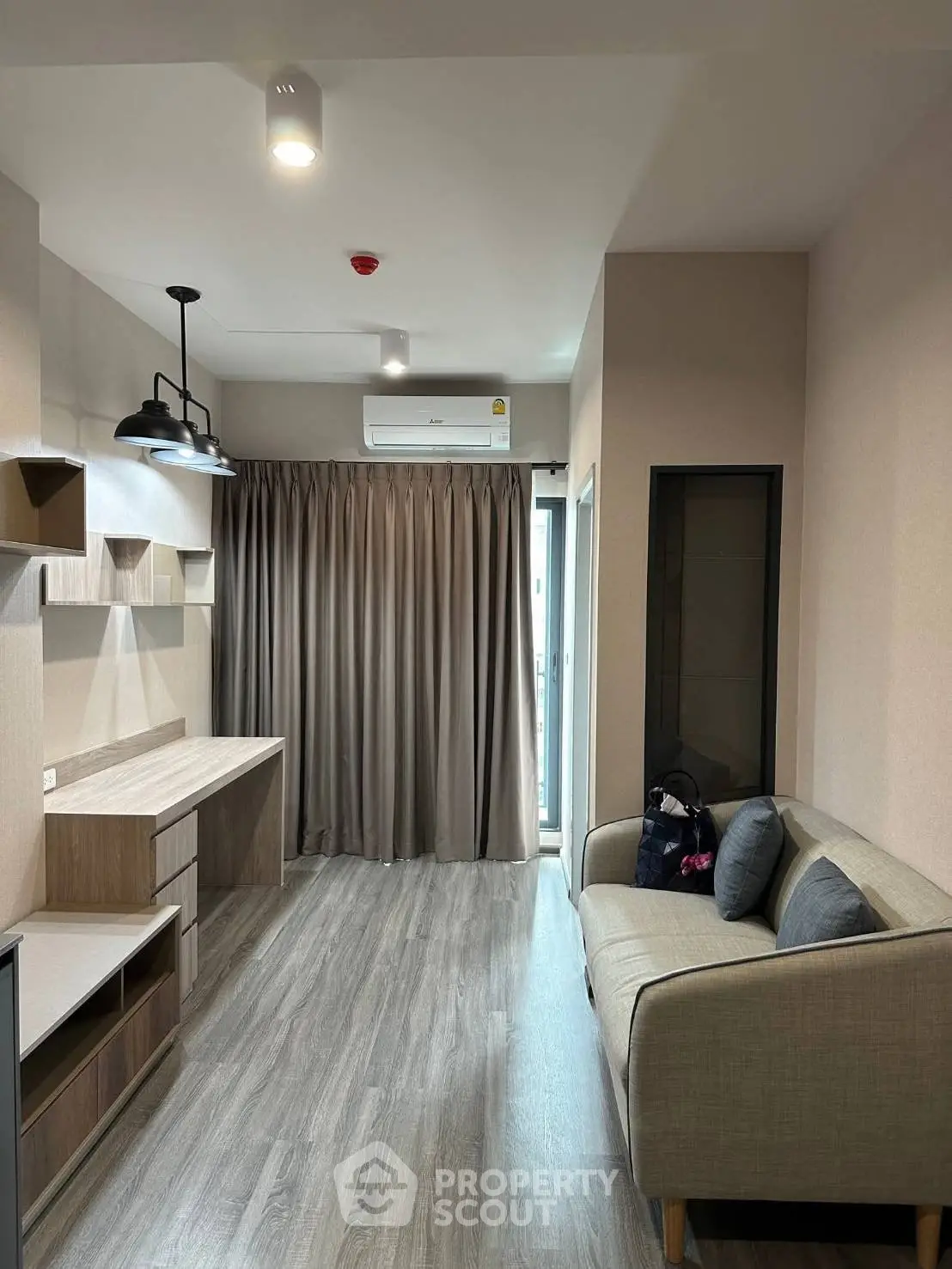 Modern living room with sleek design, featuring a cozy sofa, stylish lighting, and elegant flooring.