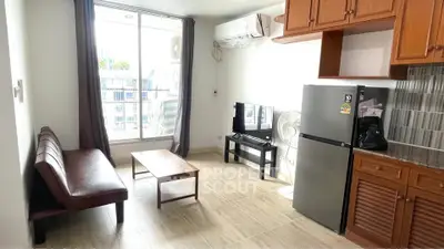 Cozy living room with modern furniture and large window offering city views.