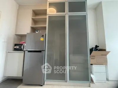 Modern kitchen with sleek fridge and ample storage in compact apartment