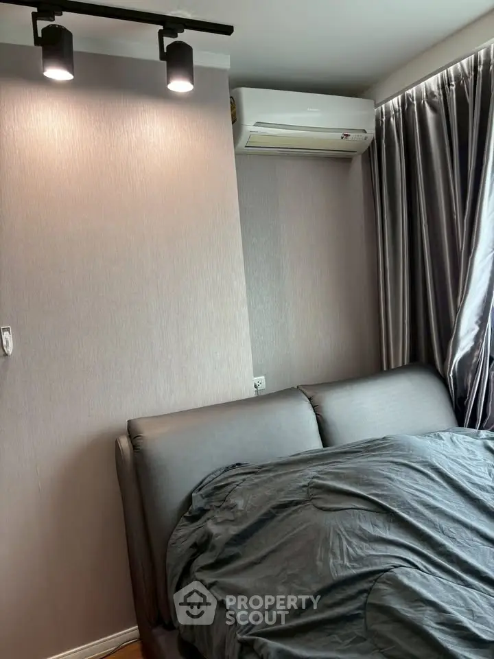 Cozy bedroom with modern lighting and air conditioning, featuring elegant curtains and a comfortable bed.