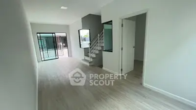Modern interior with open layout, featuring sleek staircase and natural light, ideal for contemporary living.