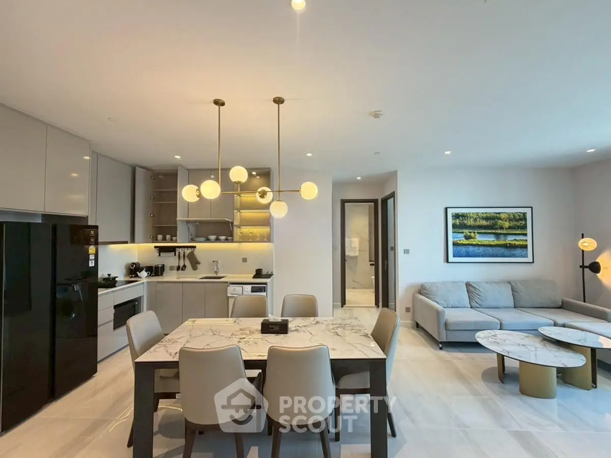 Modern open-layout kitchen and living room with elegant dining area and stylish decor.