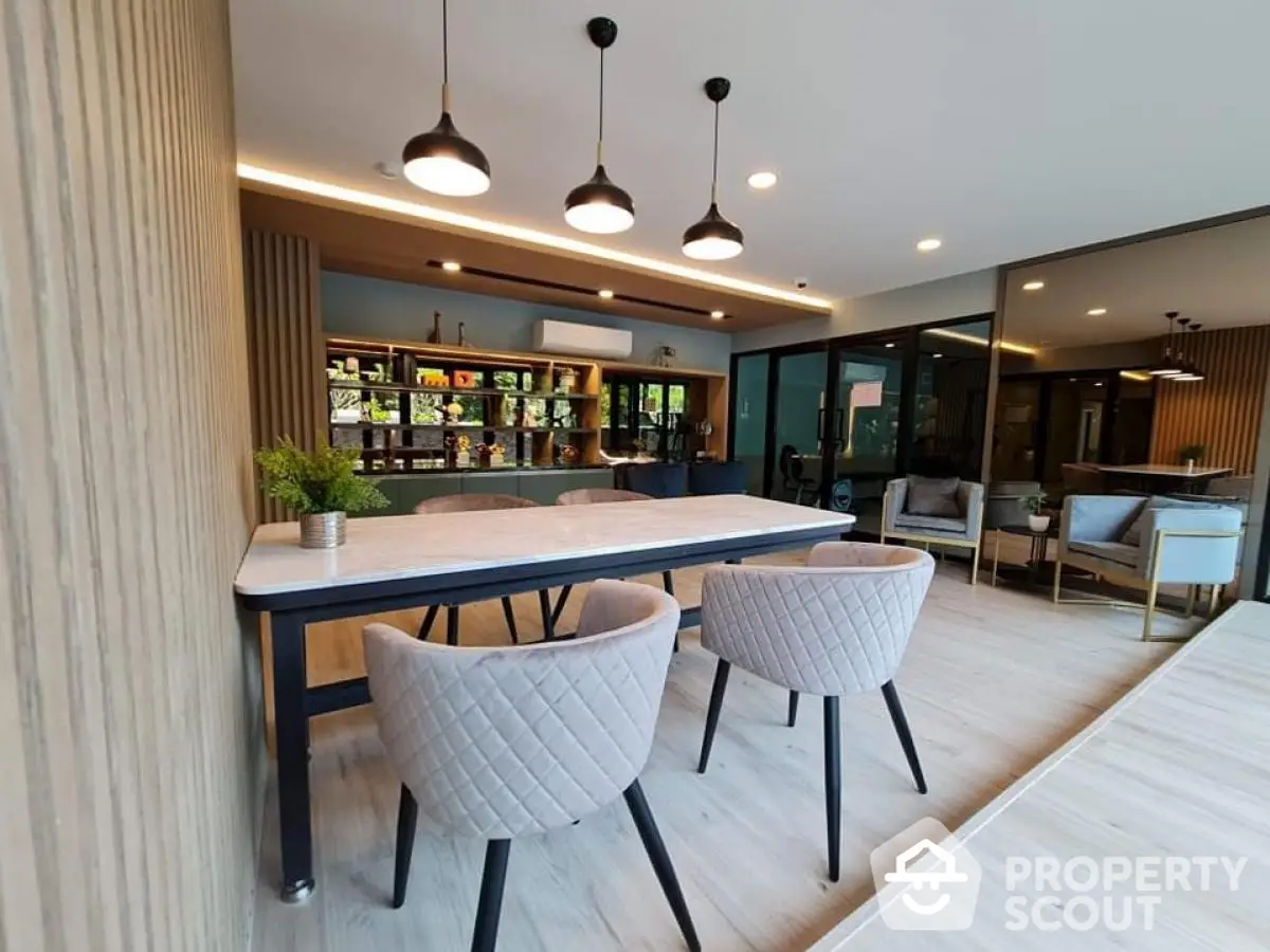 Modern dining area with stylish chairs and elegant lighting in a contemporary home.