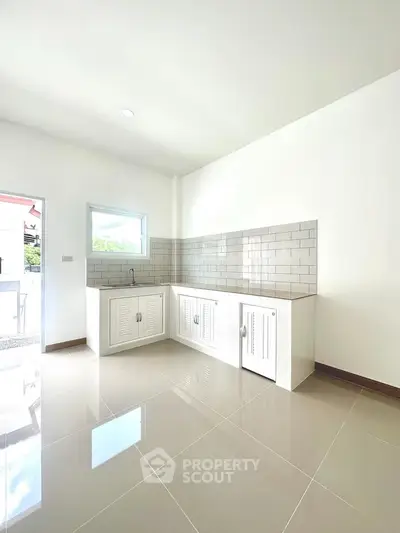 Bright modern kitchen with sleek white cabinets and glossy tiled floor