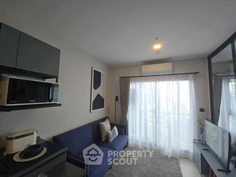 Modern living room with blue sofa, large window, and sleek decor