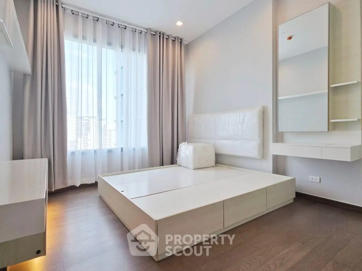 Modern minimalist bedroom with large window and sleek furnishings