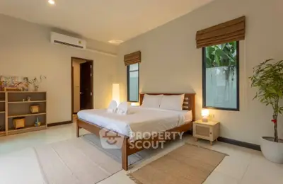 Spacious bedroom with modern decor and natural light, featuring a cozy bed and stylish furnishings.