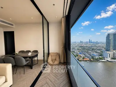 Stunning high-rise apartment with panoramic city and river views, featuring modern dining area and floor-to-ceiling windows.
