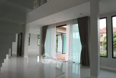 Spacious modern living area with large windows and elegant curtains