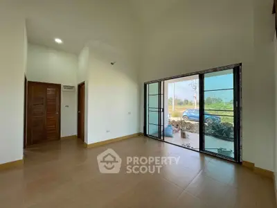 Spacious living room with large windows offering natural light and scenic views, perfect for modern living.