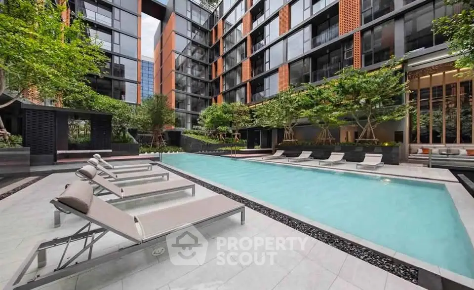 Luxurious modern apartment complex with a stunning outdoor pool and lush greenery.