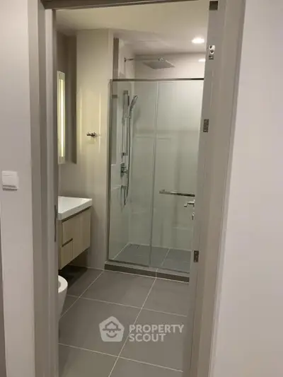 Modern bathroom with glass shower enclosure and sleek fixtures