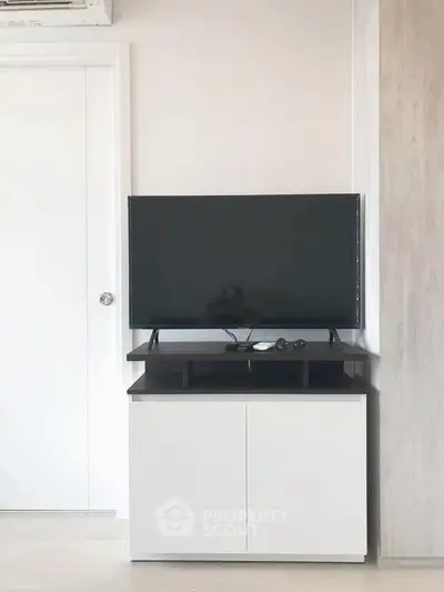 Modern living room with sleek TV stand and flat-screen TV, perfect for entertainment setup.