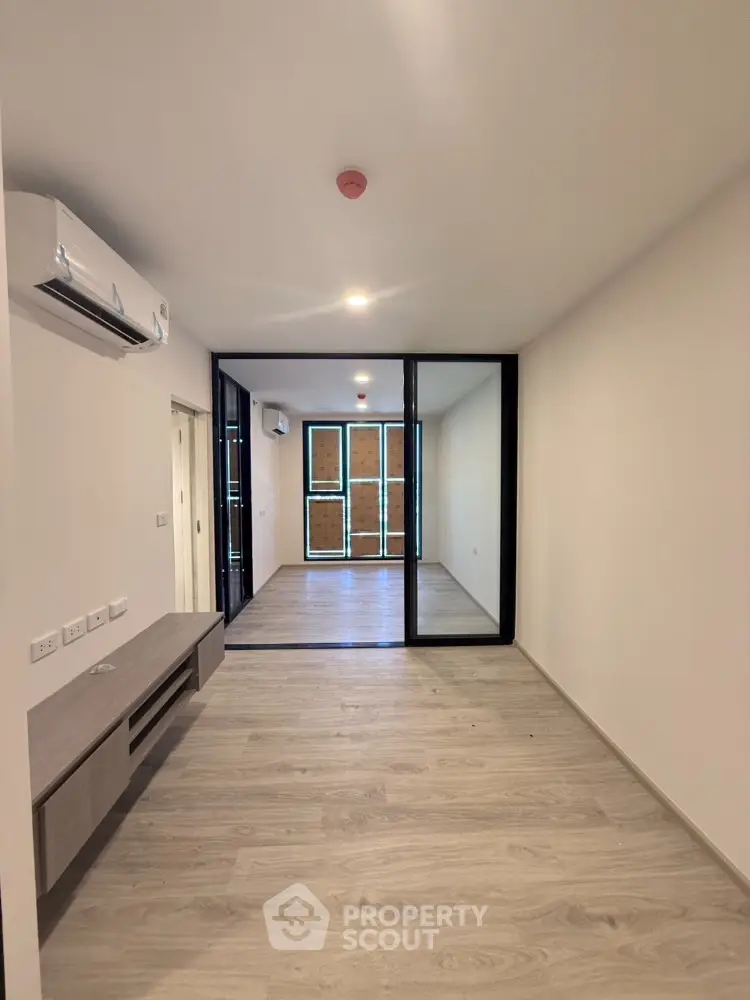 Modern unfurnished apartment interior with wooden flooring and air conditioning