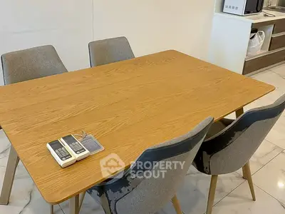 Modern dining area with wooden table and gray chairs in a stylish kitchen setting.