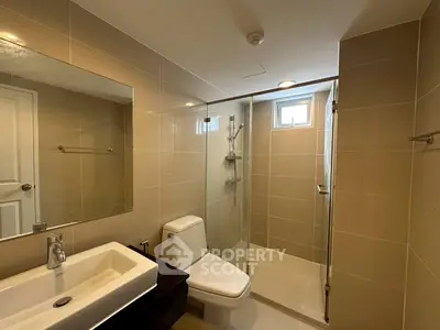 Modern bathroom with glass shower and sleek fixtures in a contemporary home.