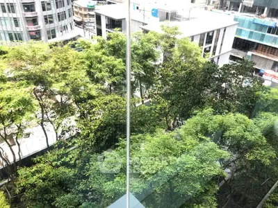 Stunning urban view from a high-rise building with lush greenery and modern architecture.