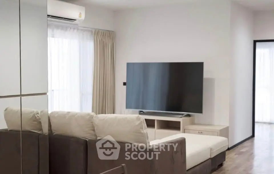 Modern living room with sleek design and large TV, perfect for relaxation and entertainment.
