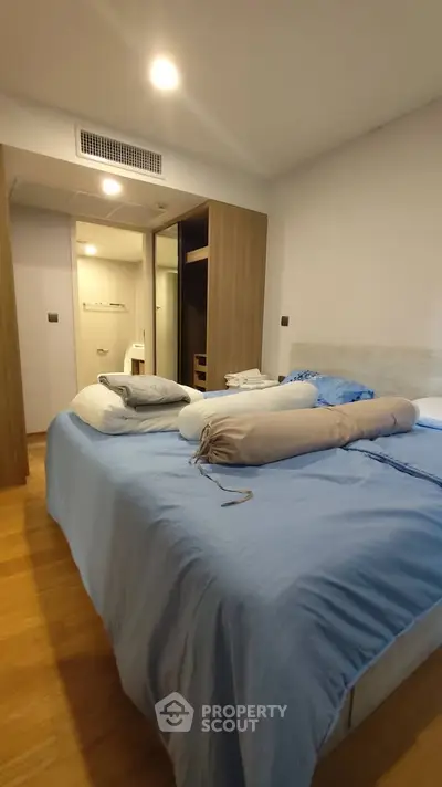 Cozy bedroom with modern design and ample storage space, featuring a comfortable bed and wooden flooring.