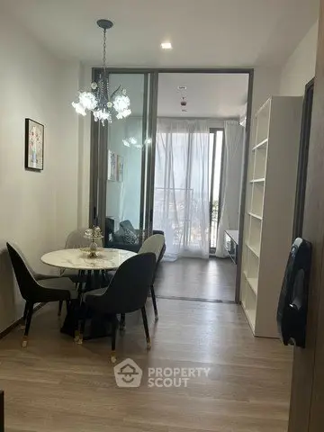 Modern dining area with elegant chandelier and open view to bedroom