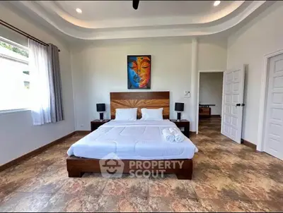 Spacious bedroom with modern decor and large windows in a luxury property.