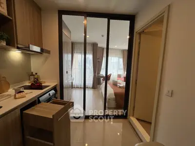 Modern open-layout kitchen with sleek appliances and view into cozy living room.