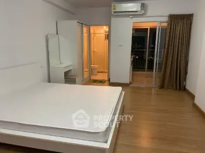Spacious bedroom with balcony access and ensuite bathroom in modern apartment.